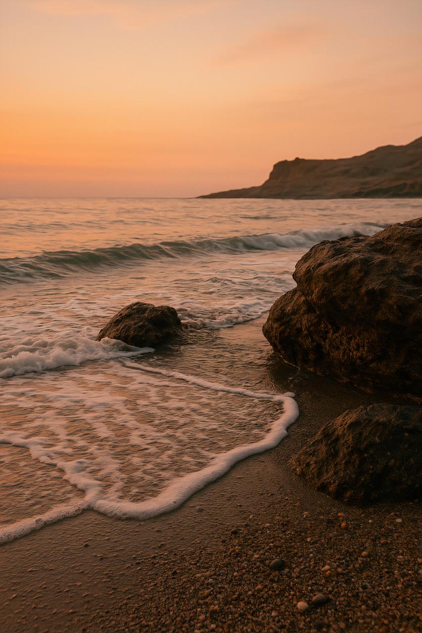 Coastal sunset beach with waves, rocks, and horizon