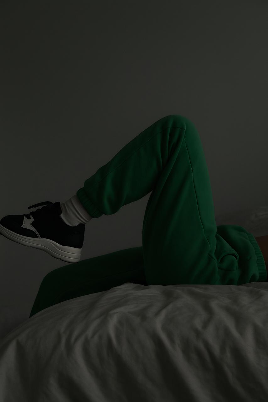 Person in sportswear sitting with crossed leg, wearing sneakers and socks