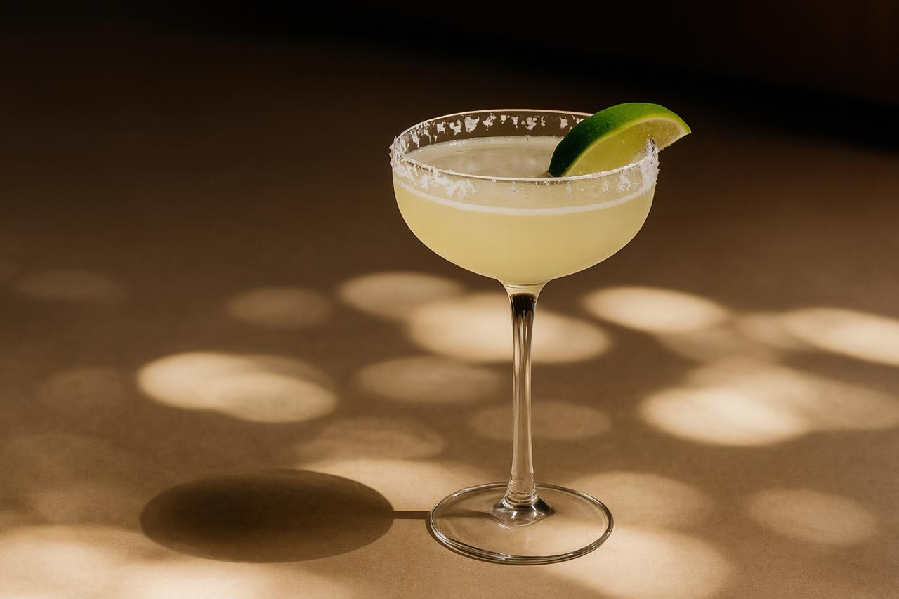 Classic cocktail table setting with assorted drinks, stemware, and garnishes