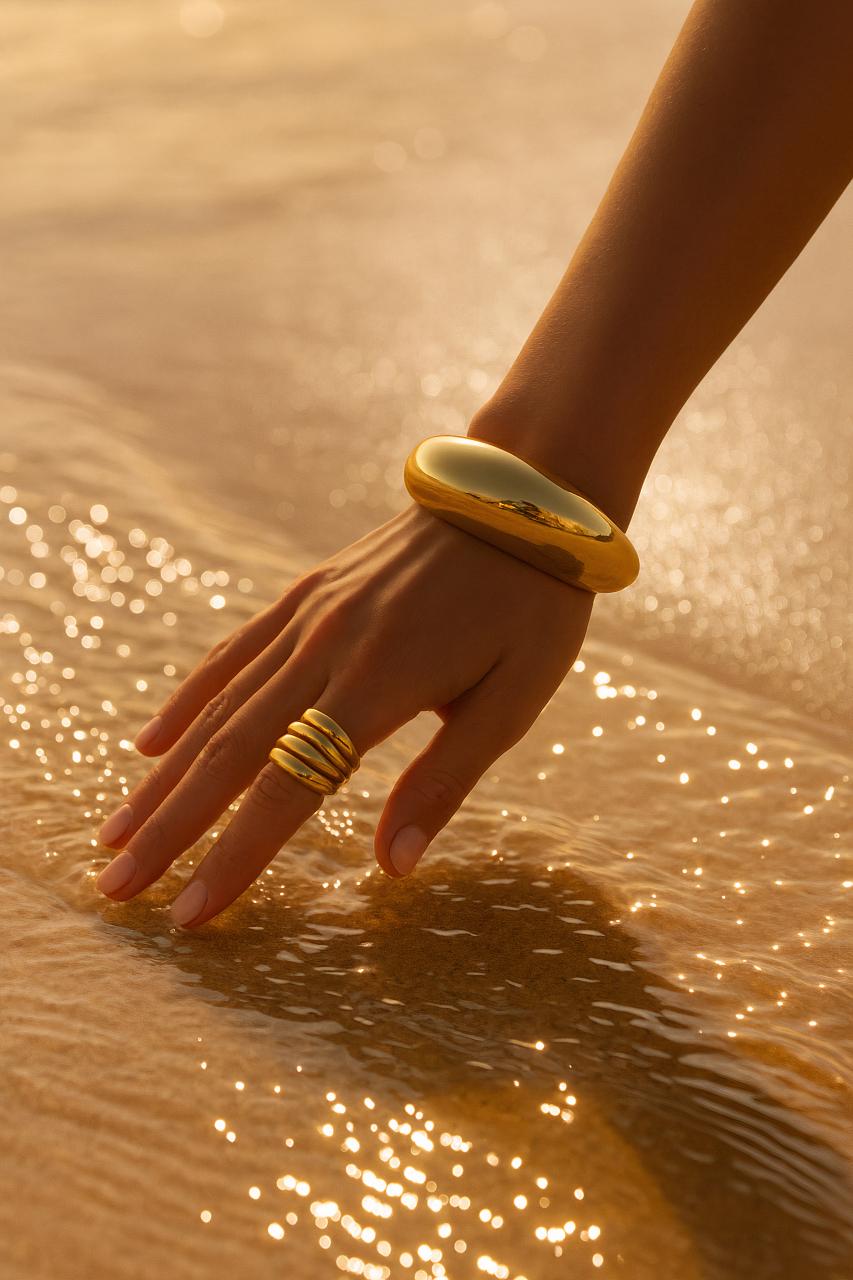 Hand with jewellery including bangles, bracelets, rings, and body jewelry