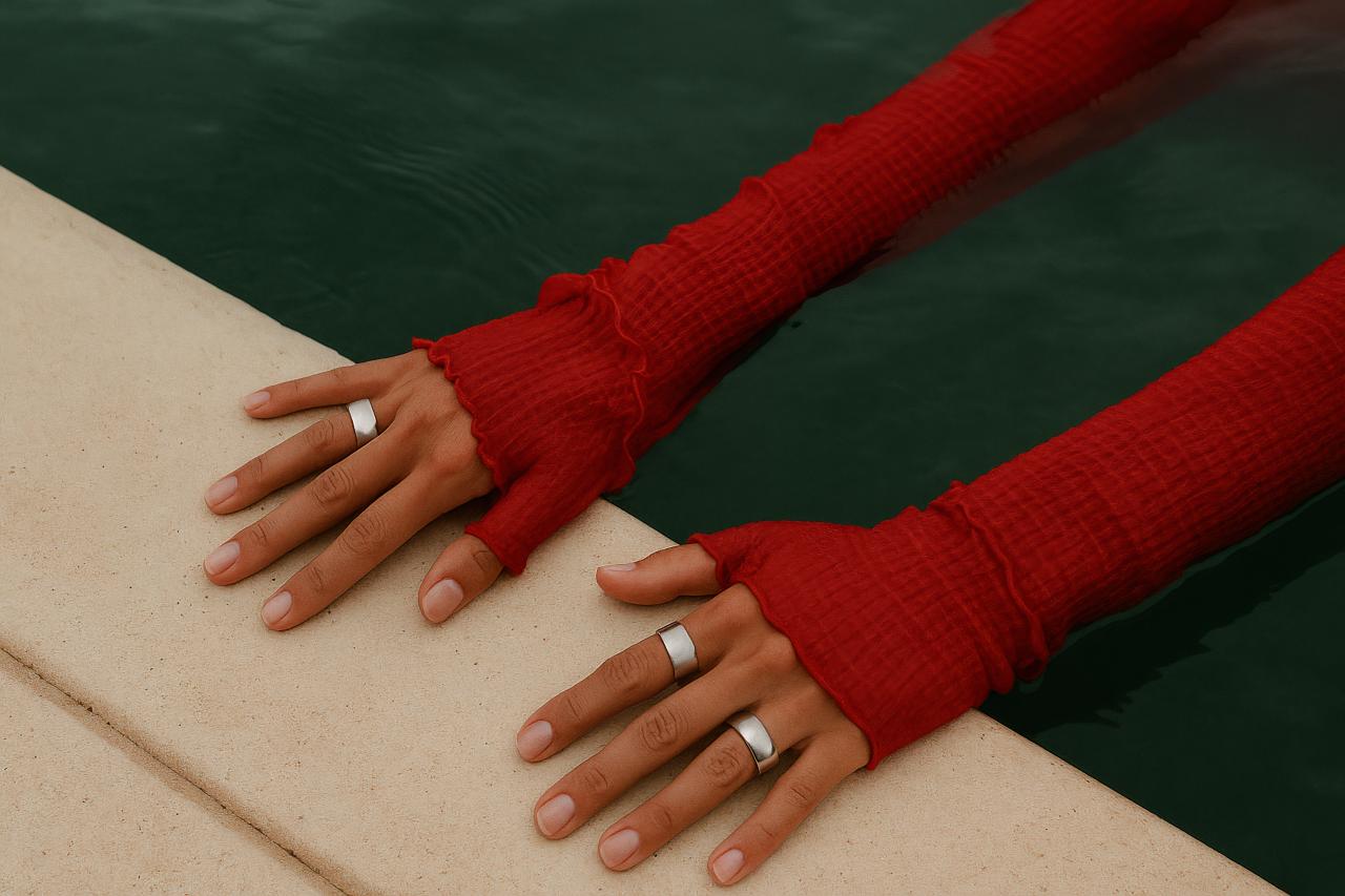 Red woolen evening glove covering hand with engagement ring
