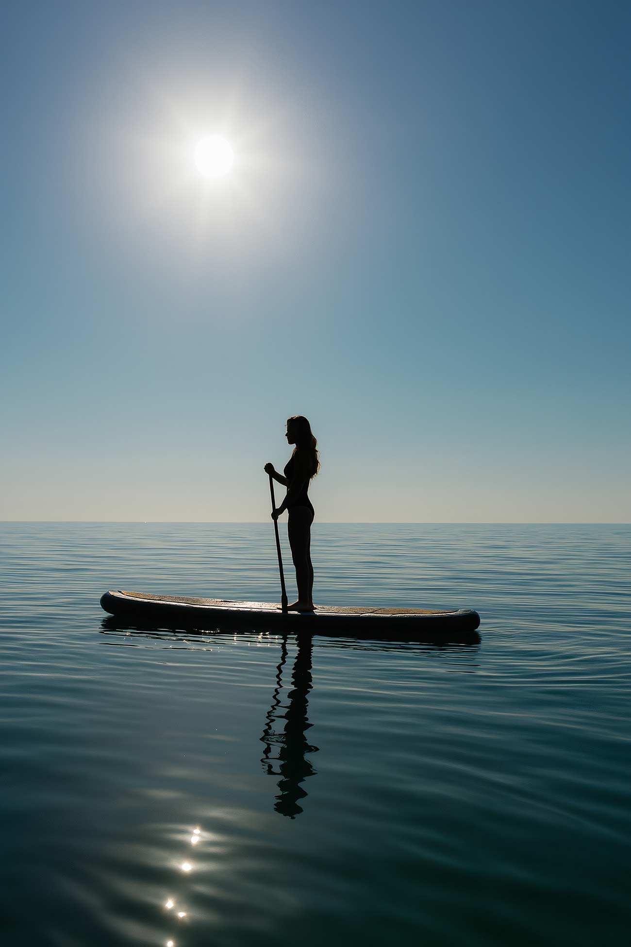 Standup paddleboarding on sea with oar and surfboard