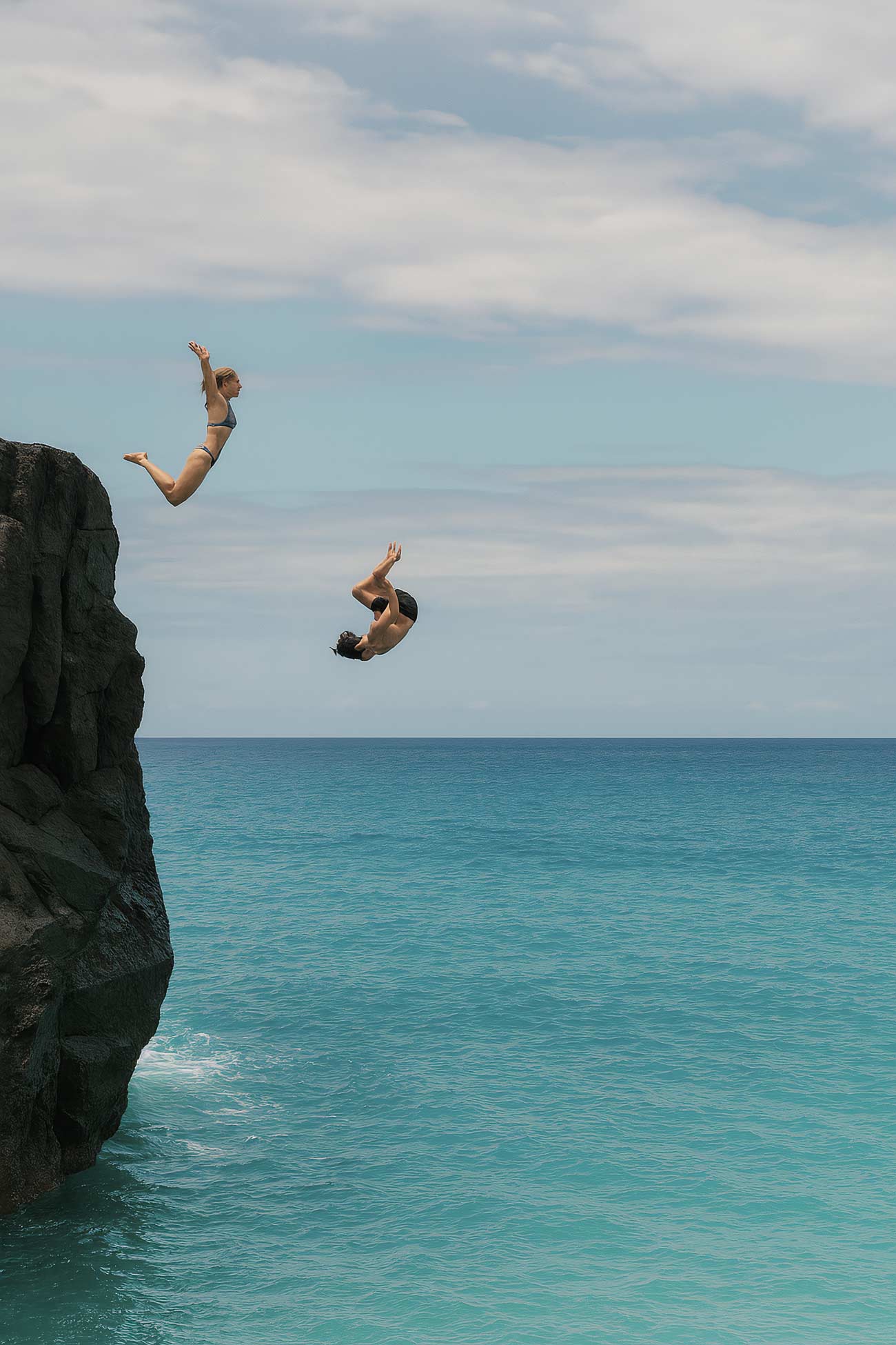 Cliff diver jumping into ocean