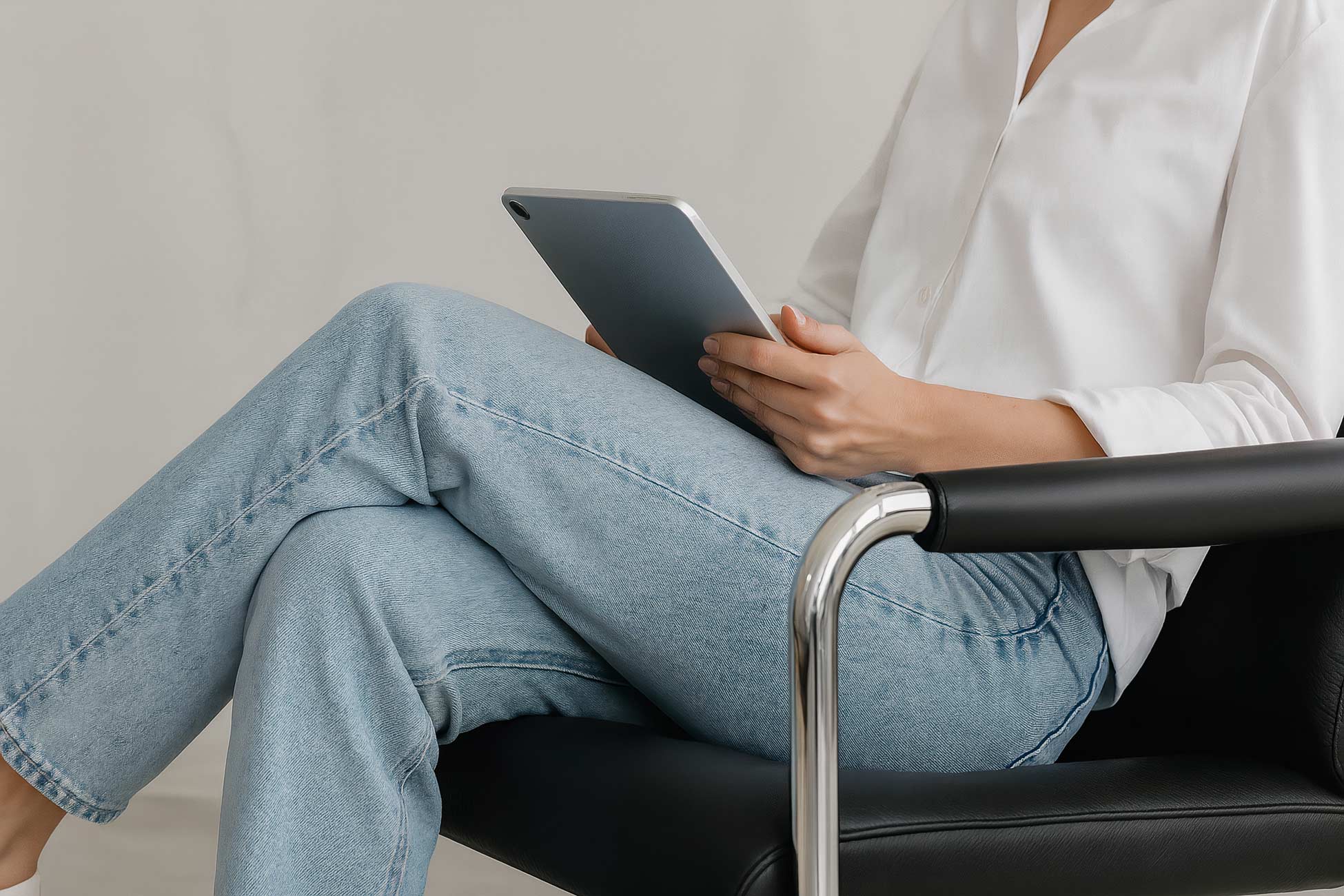 Comfortable chair with person sitting, e-reader, office supplies, book