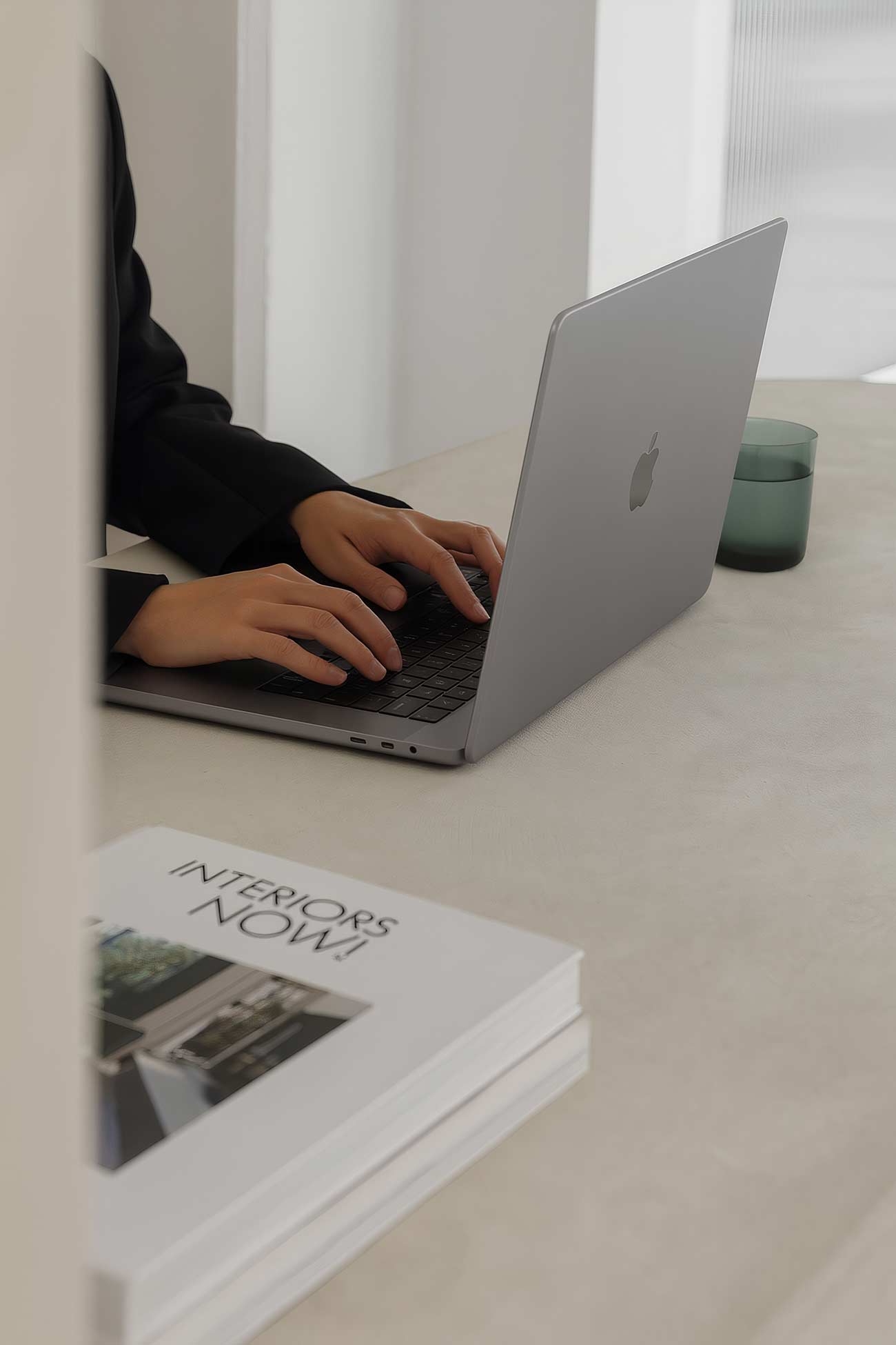 Person sitting at desk with laptop and office supplies