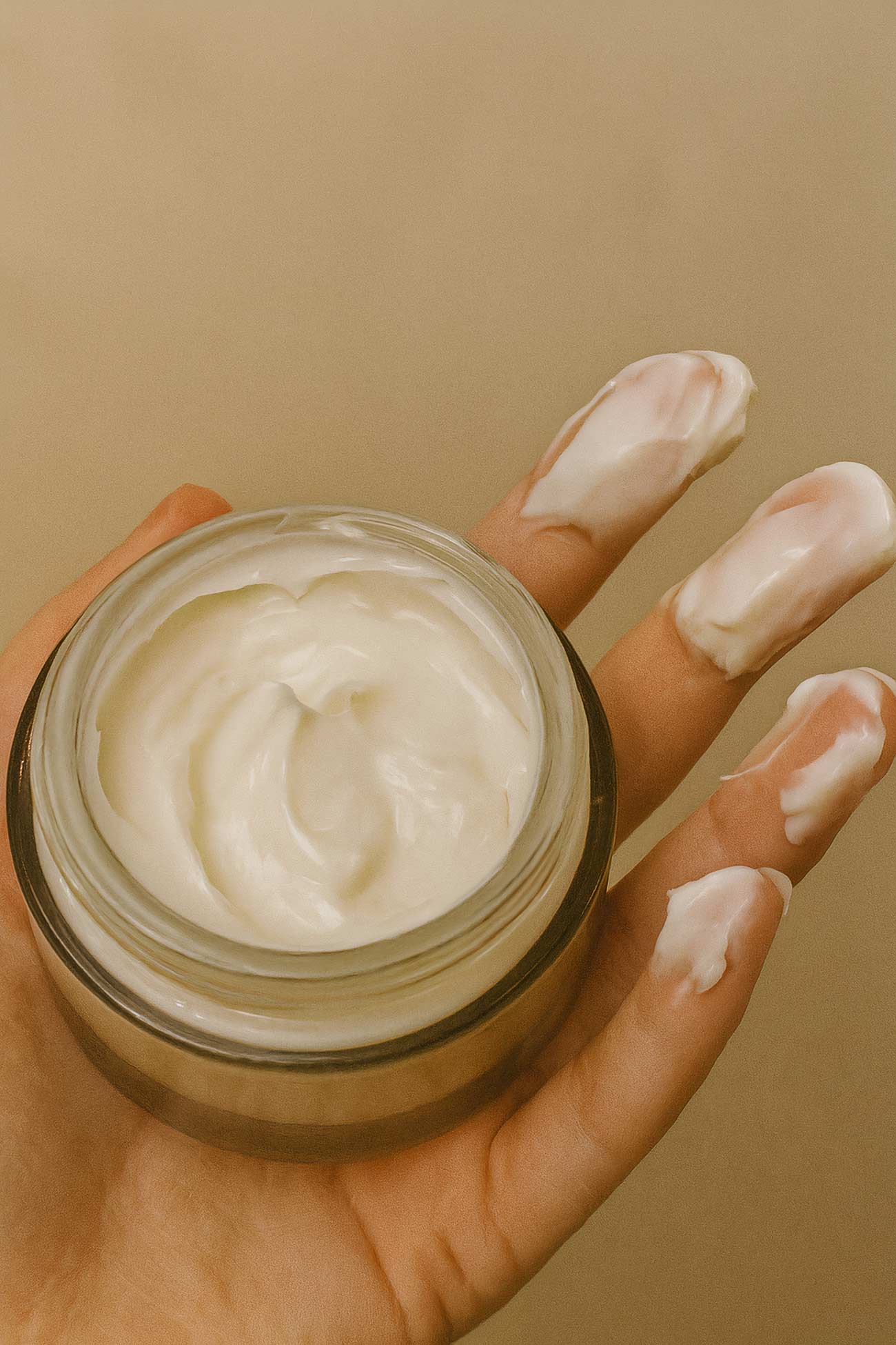 Hand holding skin care cream jar, H&M cosmetics
