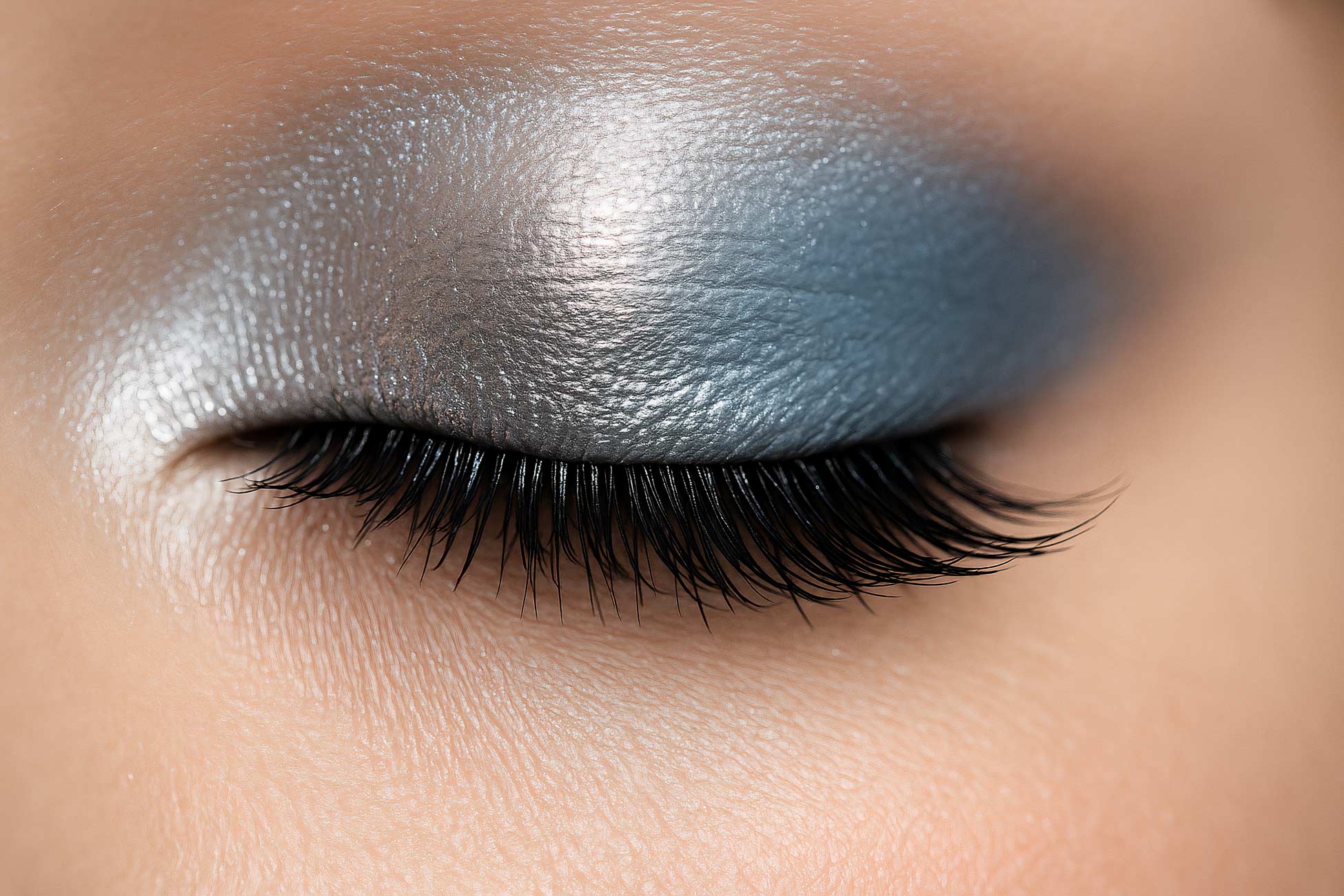 Close-up of blue and purple eyeshadow, eyeliner, mascara, and eyelash extensions