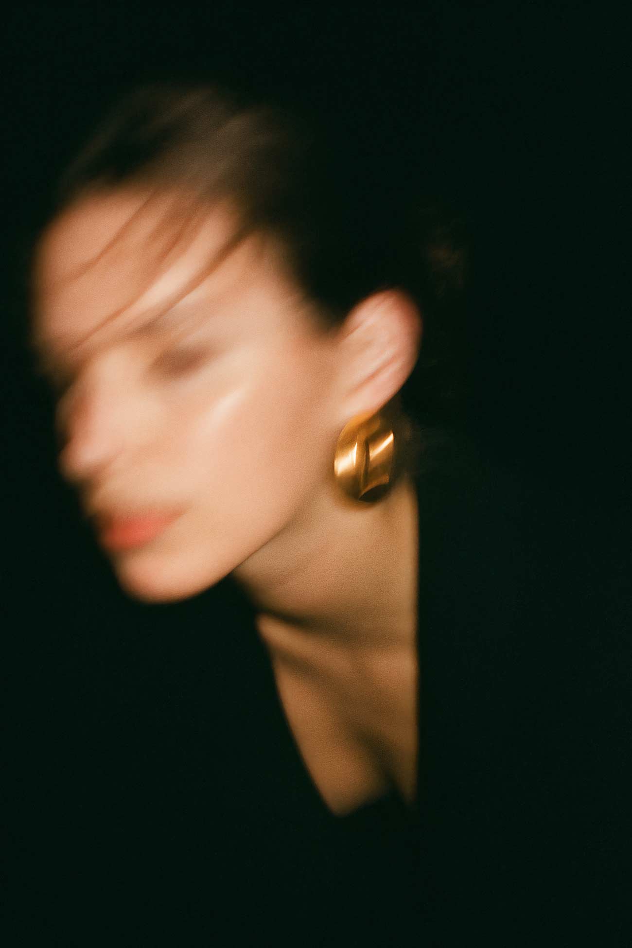 Girl with black hair and earring in portrait