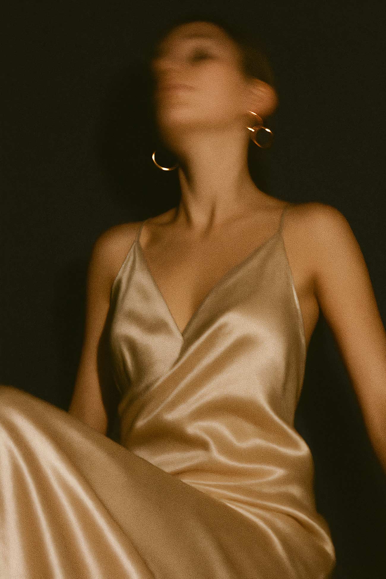 Fashion model in silk satin dress sitting
