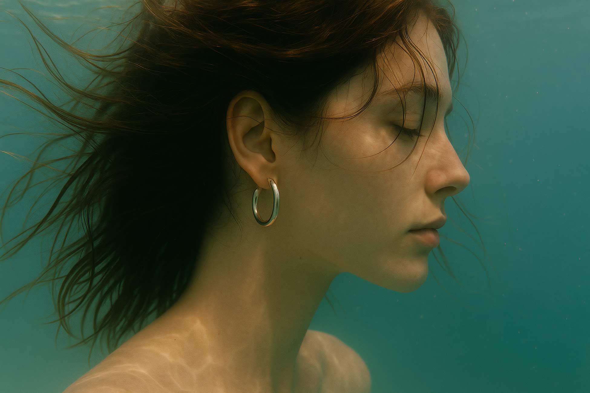 Beautiful girl with black hair underwater, lips and neck detail
