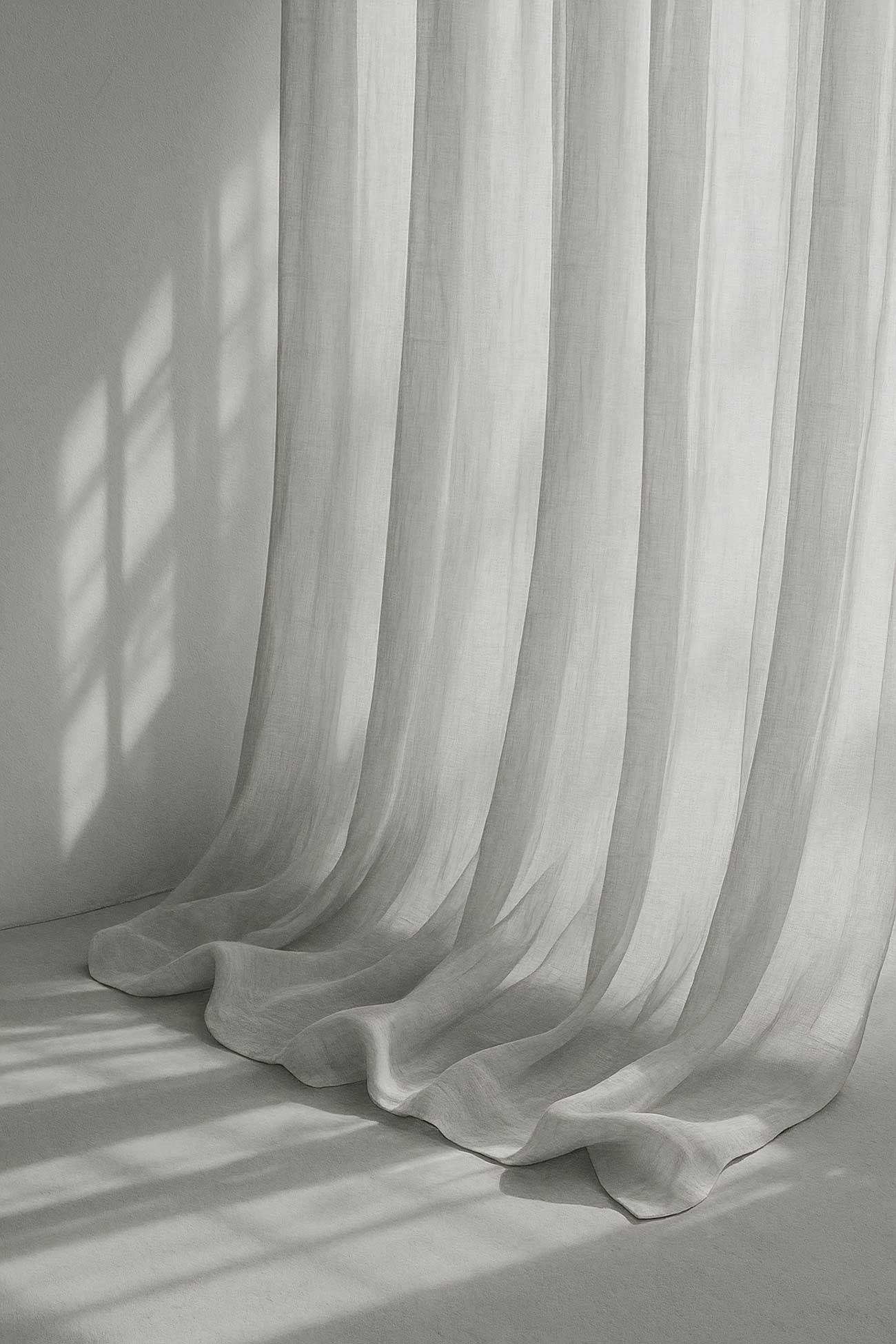 White and grey curtain with silver accents in a window