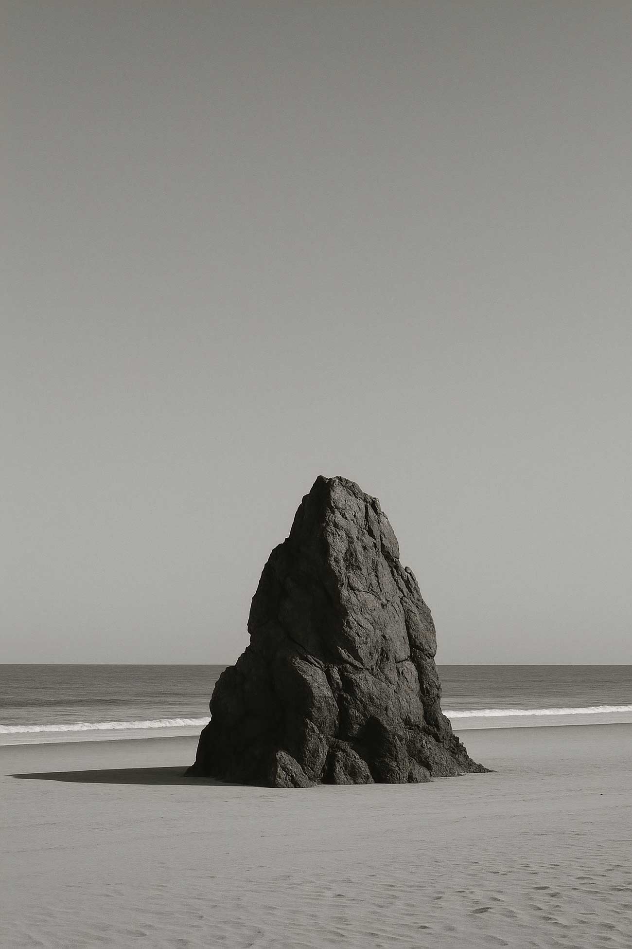 Monochrome ocean landscape with rocky outcrop and horizon
